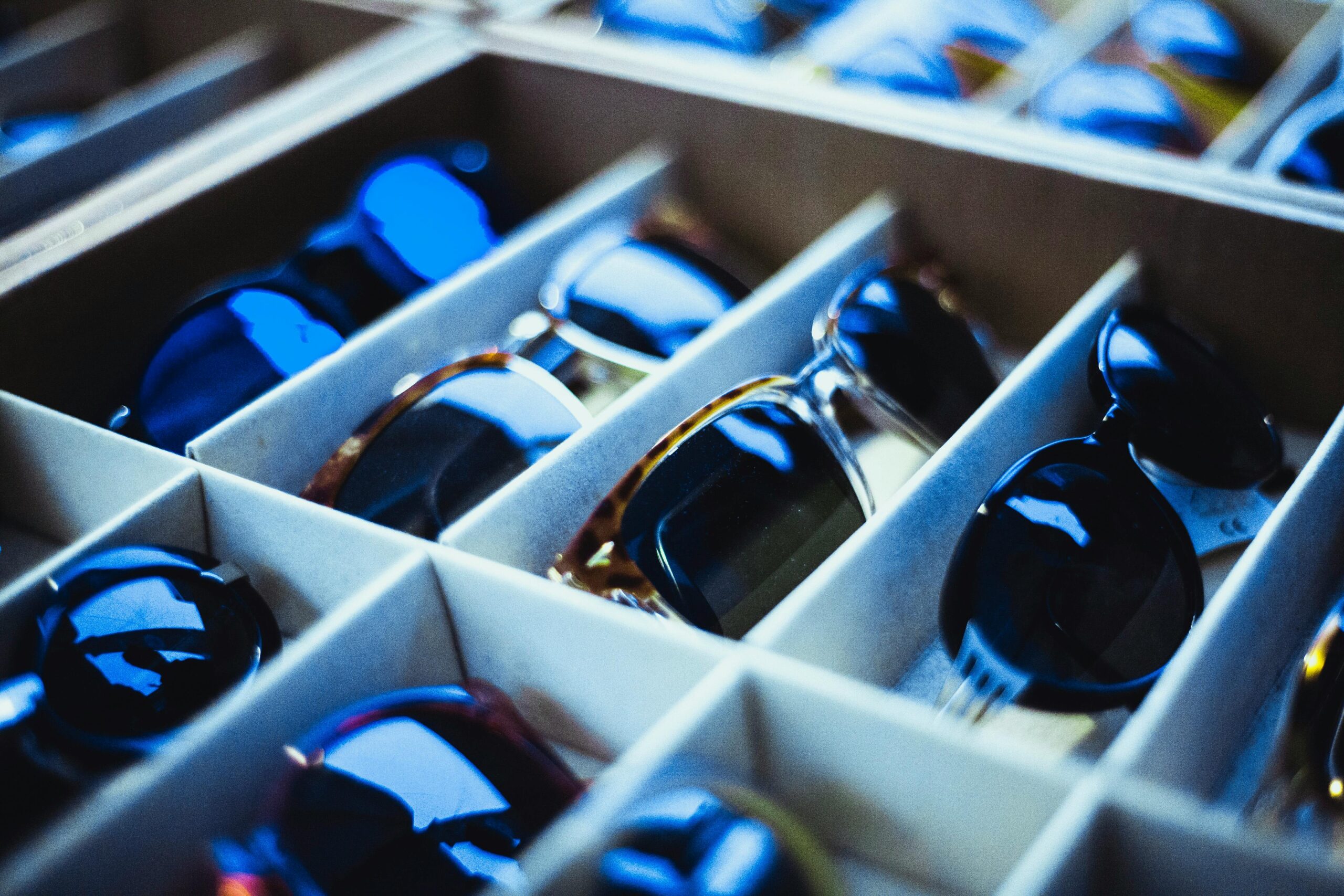 Close-up view of assorted sunglasses neatly arranged in display racks.